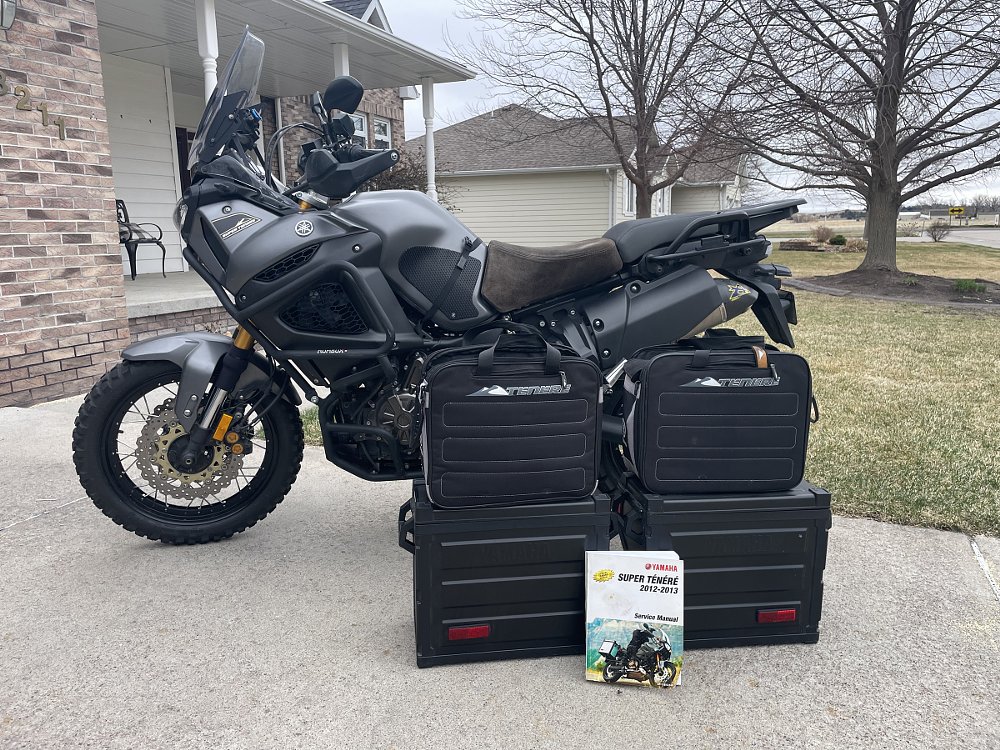 a 'for sale' photo of the Super Tenere with accessories and shop manual placed in front of the motorcycle