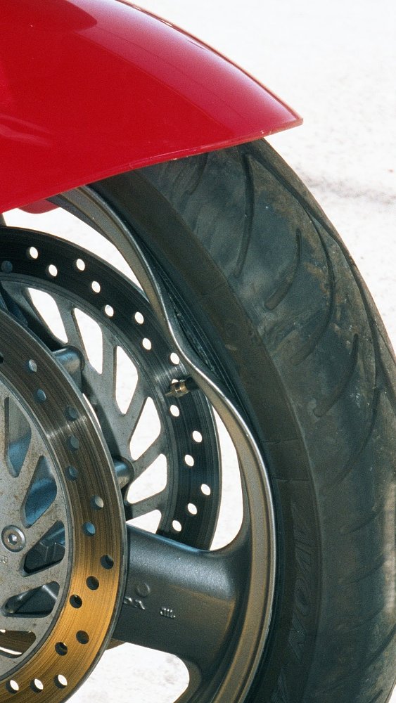 close view of the front wheel of the ST1100 with a big dent in the rim