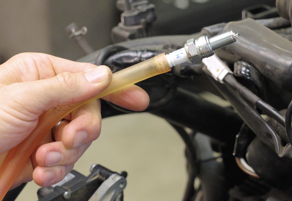 Using a rubber hose to remove or install a spark plug