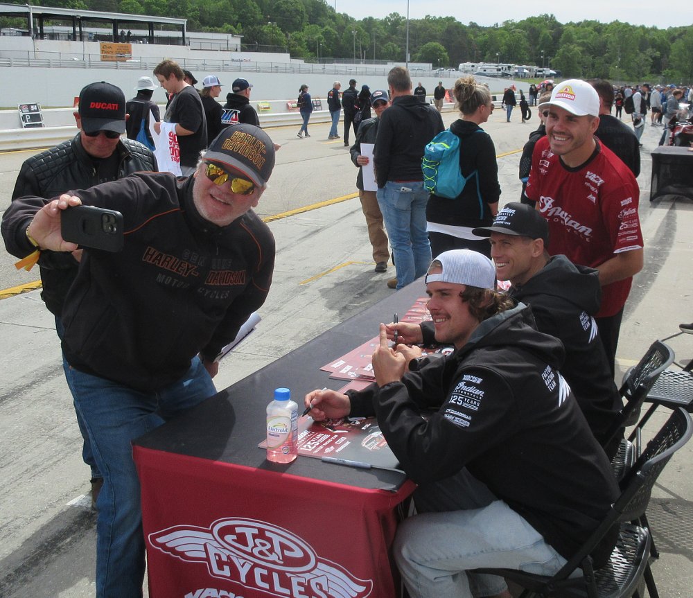 fan wearing a H-D hat takes a selfie with the three Indian Factory riders
