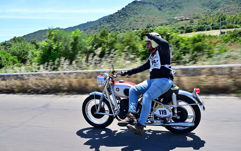 rider riding sidesaddle on a vintage BMW in the Giro