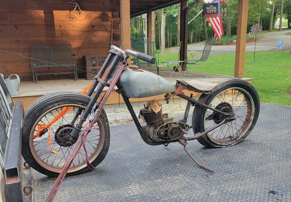 partially assembled rusty motorcycle on the back of a flatbed truck