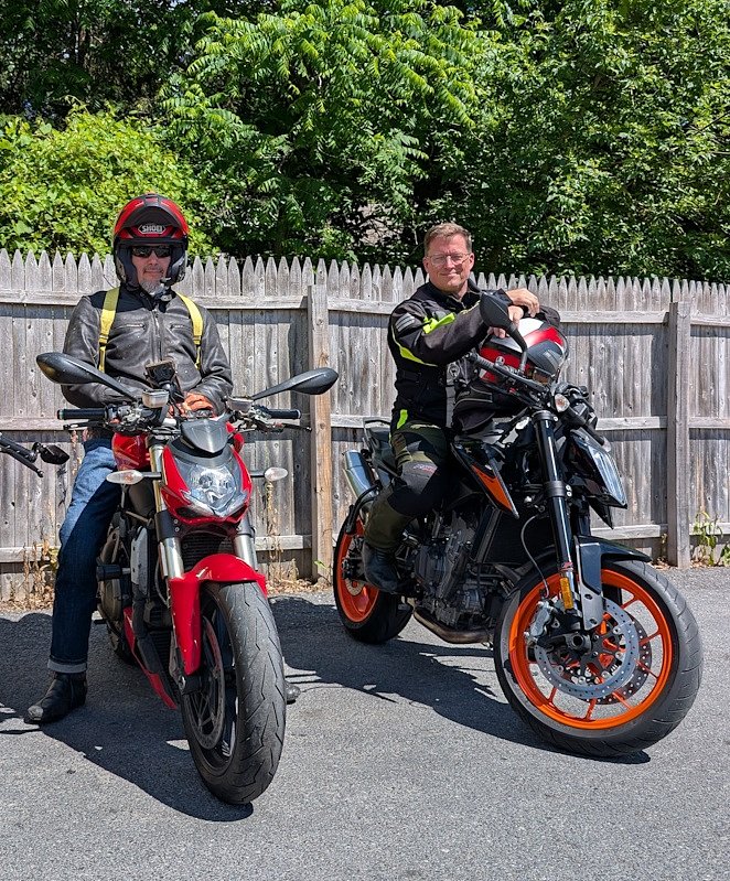 two riders stopped and smiling for the camera