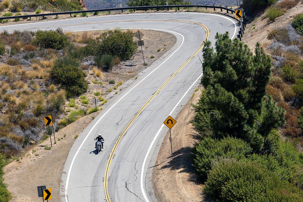 A long shot of Dustin riding the Super Glide through a canyon.