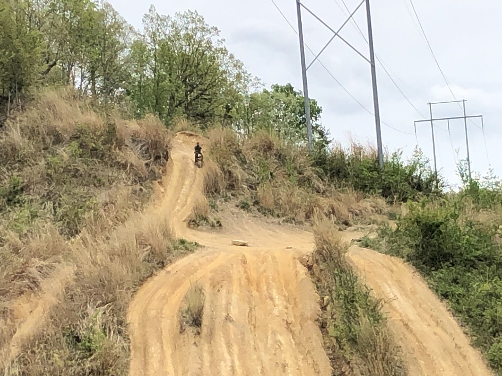 riding the minibike on a large, steep hill with a muddy road