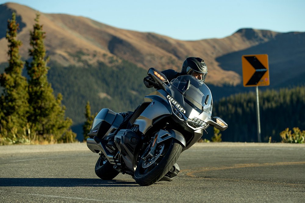 A Gold Wing rider glides through a mountside backroad.