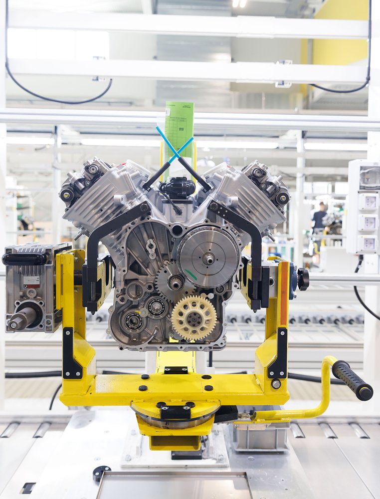 engine on a stand being conveyed through the production area of the factory