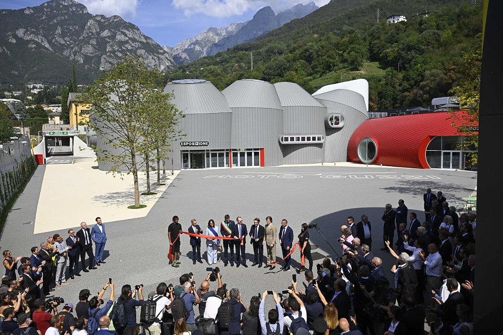 a crowd at a ribbon-cutting ceremony in front of the museum