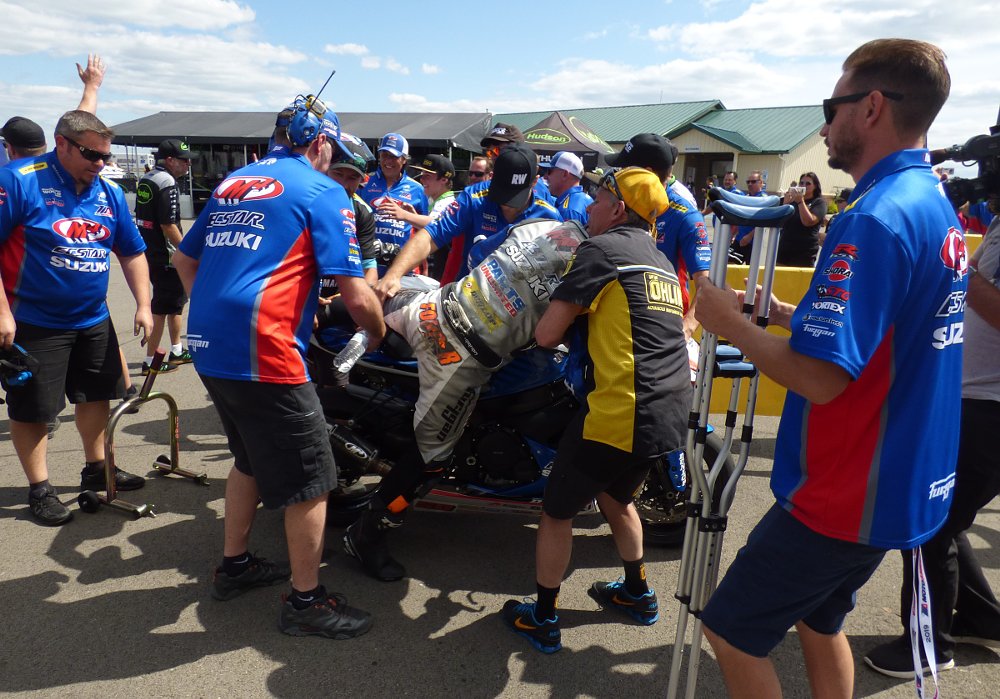 Fong helped off his motorcycle by his team after race