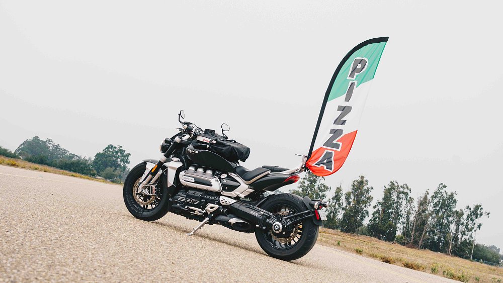 Triumph Rocket 3 with pizza feather flag mounted to tail