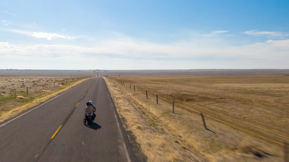 A mini bike riding across the flat plains of Colorado.
