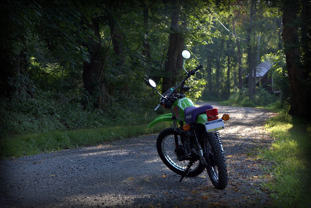 Kawasaki KE100 parked on a dirt road