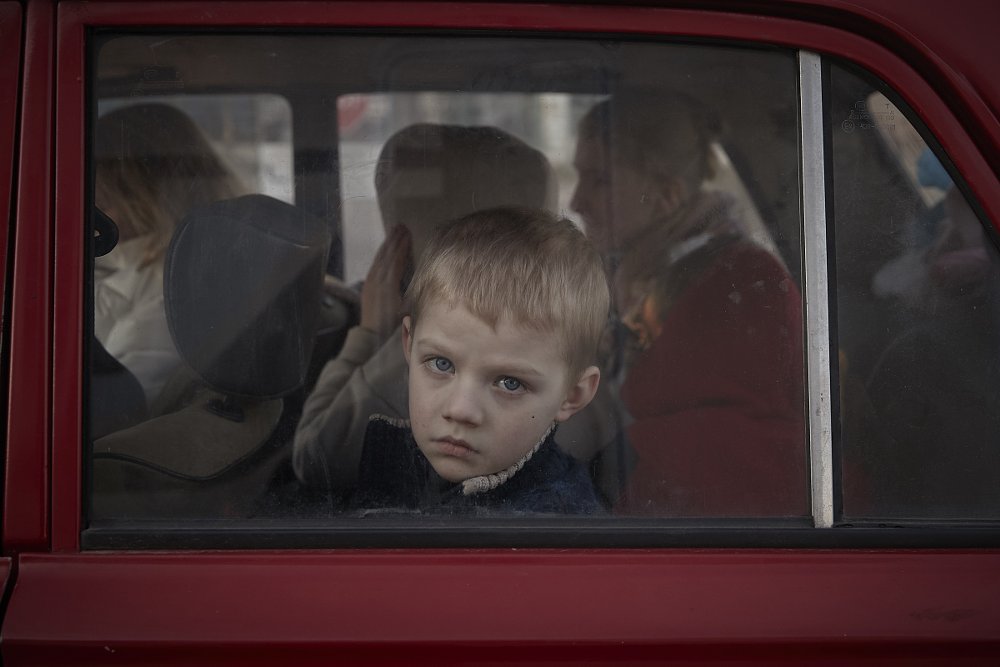 refugee boy looking out a train window