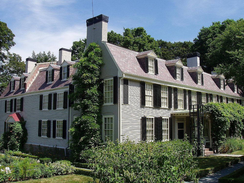 A photo of the Old House, where John Adams lived, it is a long colonial style farm house and surrounded by green trees