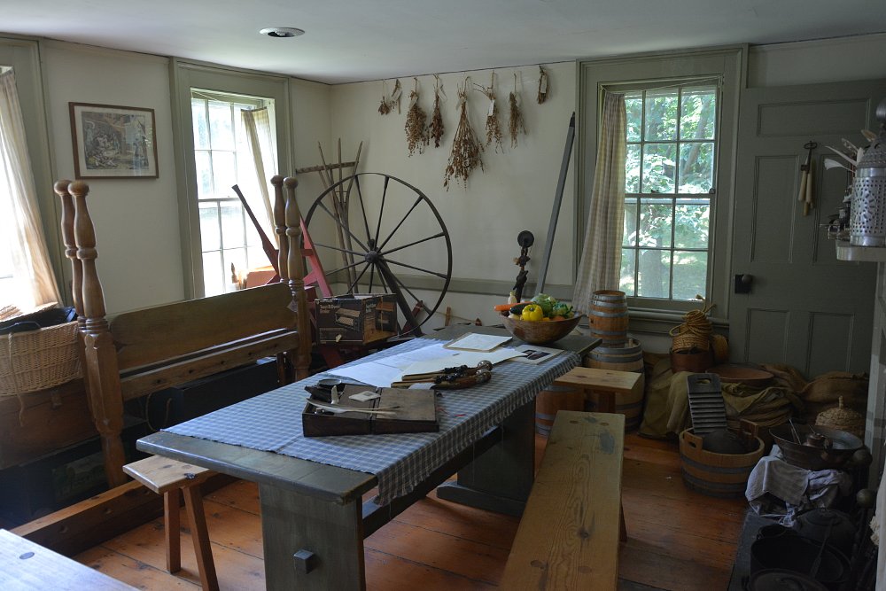 an interior photo of Thomas Paine's cottage living room, with few furnishings and simple decor