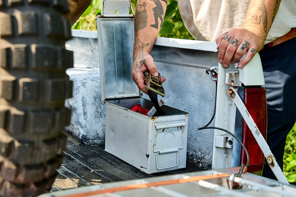 ammo can spray-painted white with tie-downs inside
