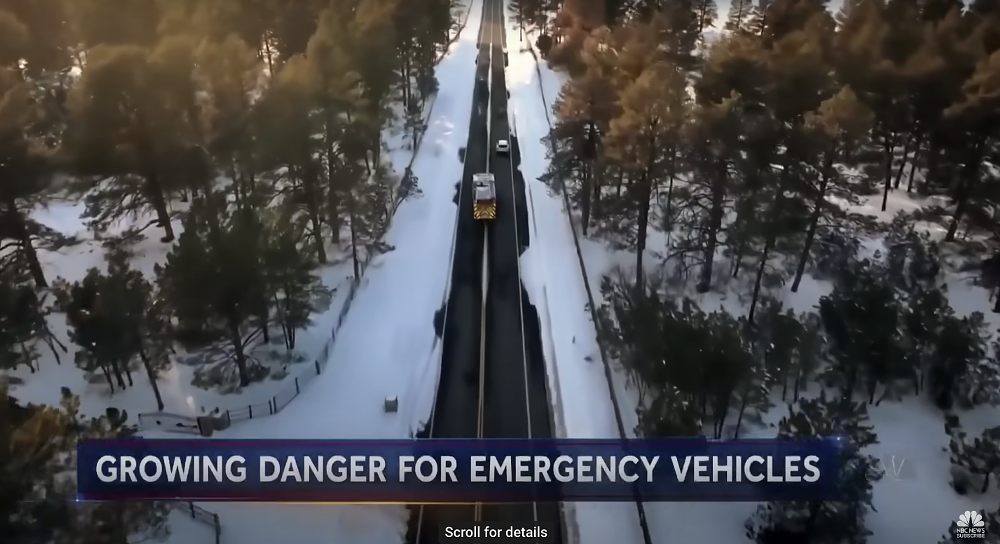 An aerial photo of a fire truck passing a black suv