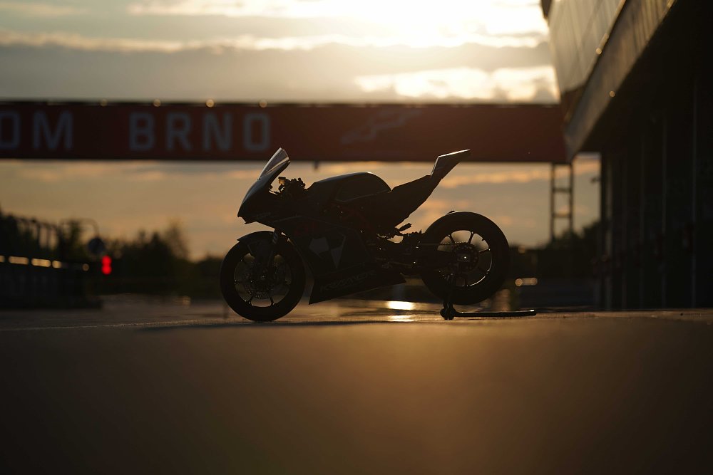 A sunset silhouette of the 2024 Kramer GP2-890RR, sitting on a paddock stand in the pit lane of the Brno Circuit in the Czech Republic.