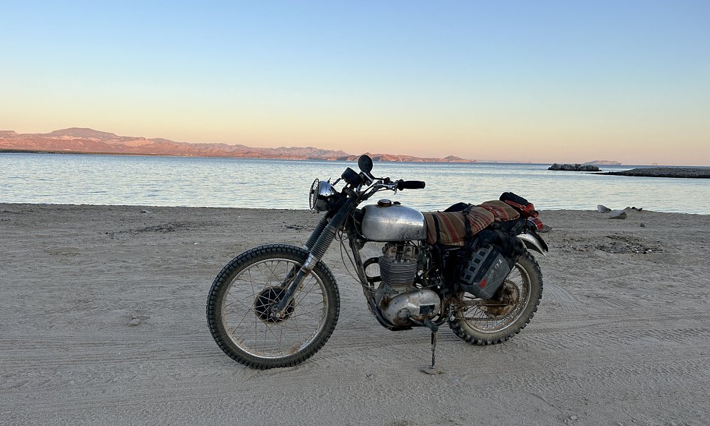 the old BSA motorcycle parked along the ocean