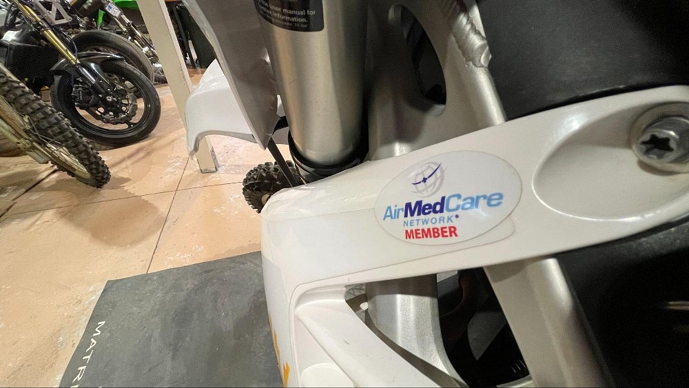 A dirt bike has a air ambulance insurance member sticker on it