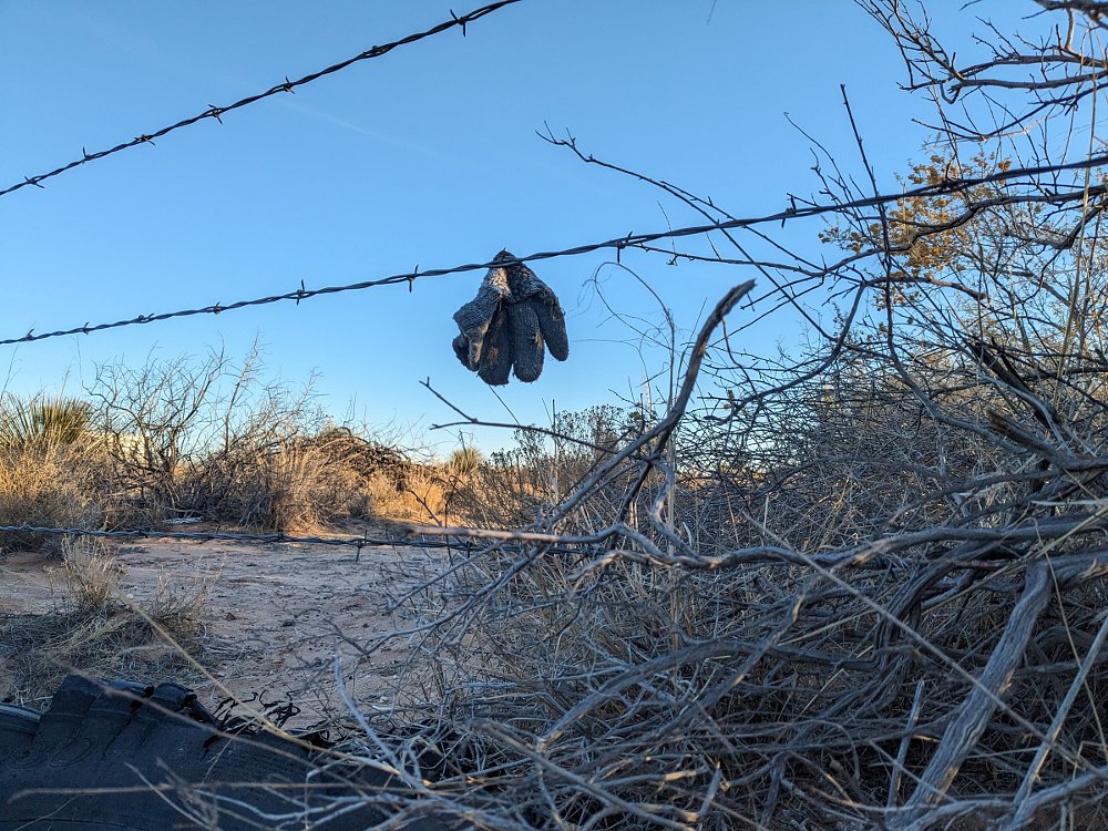 child's mitten hanging on a barbed wire fence