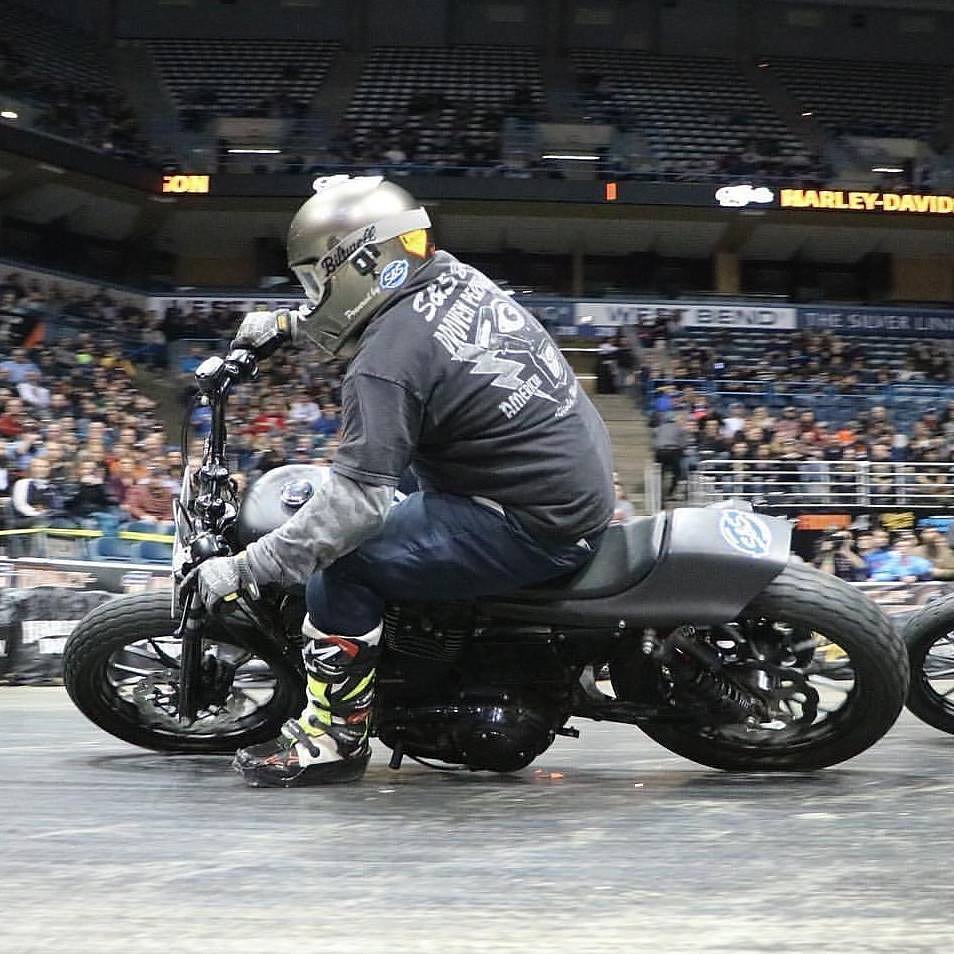 Patrick on his race bike leaned over until the engine case is nearly touching the concrete floor