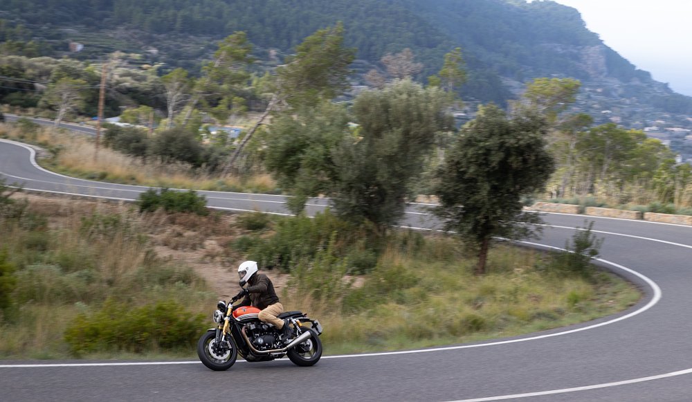 rider on the orange Speed Twin 1200 RS on a road that winds back and forth in the distance