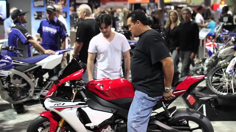 An IMS attendee swings a leg over a Yamaha YZF-R1 sport bike.