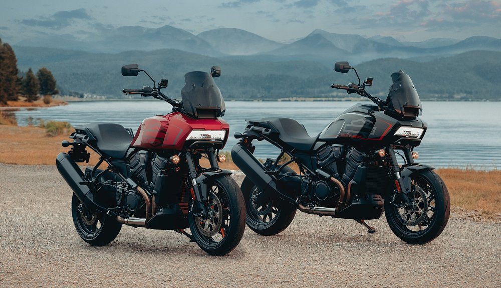 red and black Pan America 1250 ST models parked in front of a lake and mountains