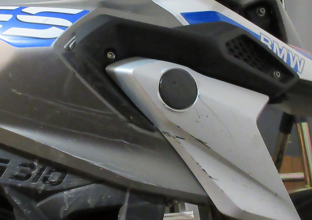 close view of damage to a dirty fairing on the G 310 GS