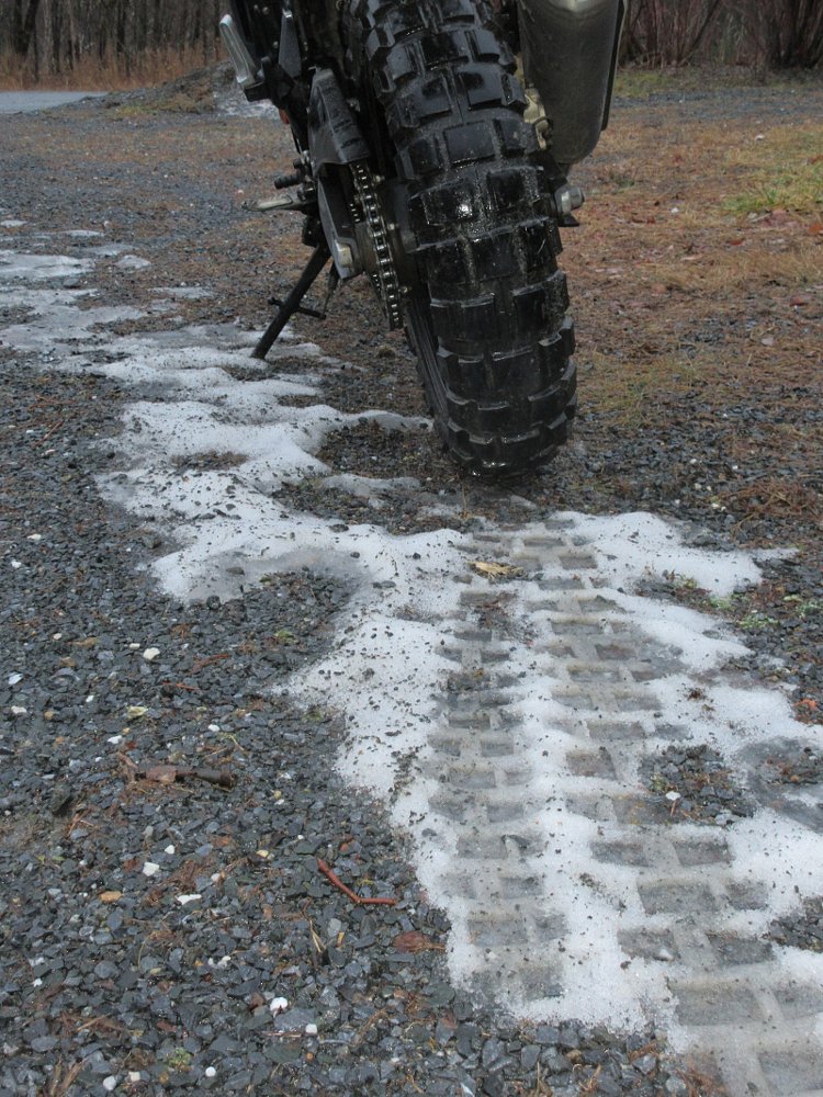 rear view of the knobby TKC80 tire in mud with a scrap of snow