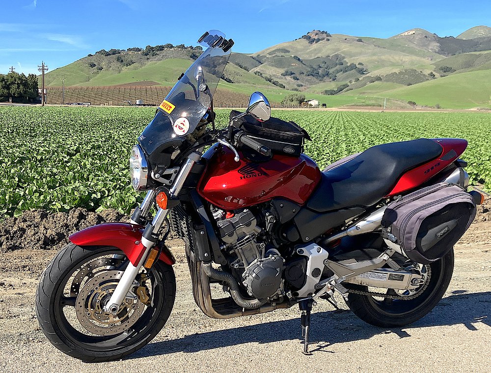 red Honda 919 with a tall windscreen parked at a vineyard