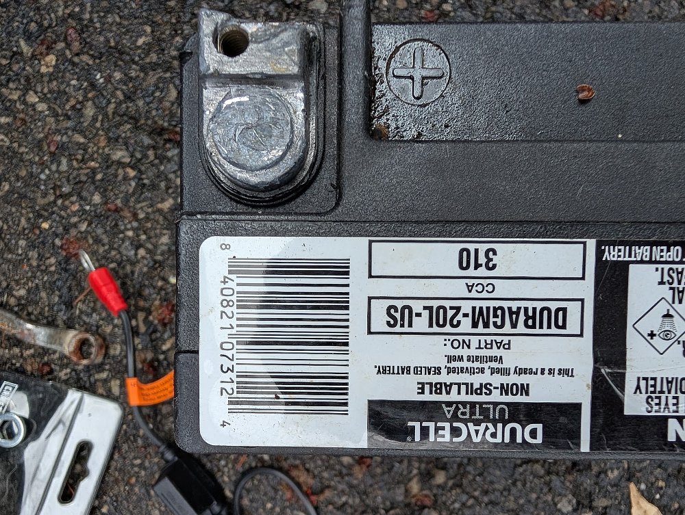 close view of a battery with a damaged and partially missing terminal