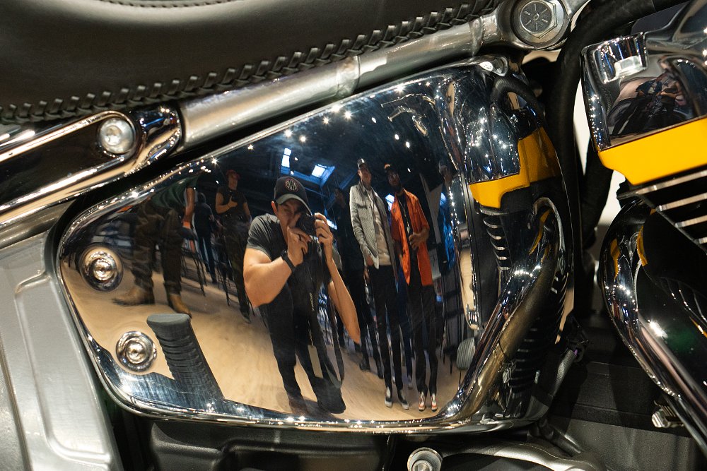 A reflection of Dustin taking a photograph of the Fat Boy Gray Ghost's chrome side cover.