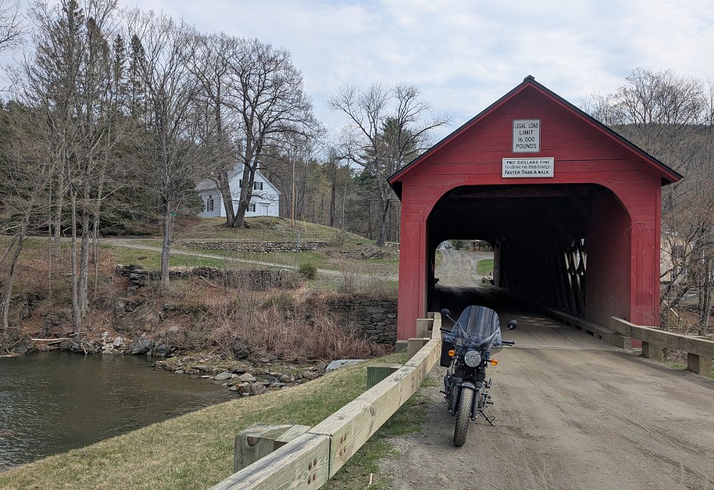 the Hunter 350 parked in front of the old red covered bridge