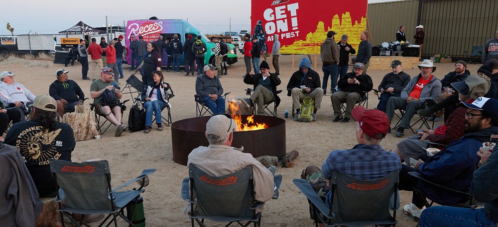 riders at a rally around a campfire at dusk