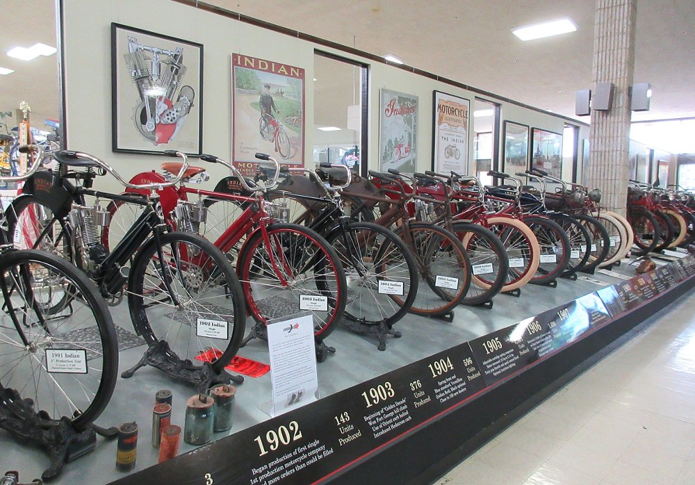 a row of early Indian motorcycles on display in the museum