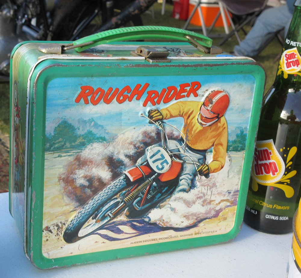 vintage, slightly battered and rusty Rough Riders metal lunch box showing an off-road rider on the front